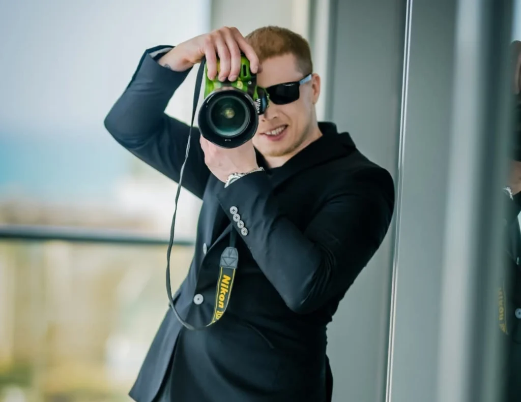 צלם נתי גולד מחזיק מצלמה לפנים